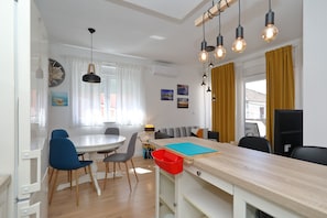 A modern kitchen with a dining area, wooden cabinets, and a built-in oven. - Apartment Bajana in Central Location (Zadar)