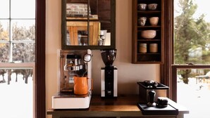 A kitchen with a coffee machine, a kettle, and a stove. - Maison Hôte (Orford)