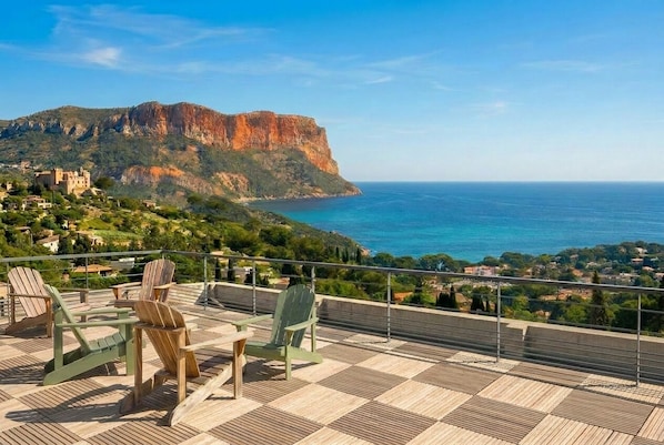 A terrace with chairs and a view of a coastal landscape with a prominent cliff. - Maison Soleil sea view Cassis (Cassis)