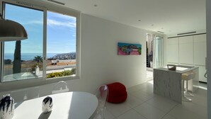 Eine moderne Küche mit großem Fenster, einem Essbereich und Meerblick.