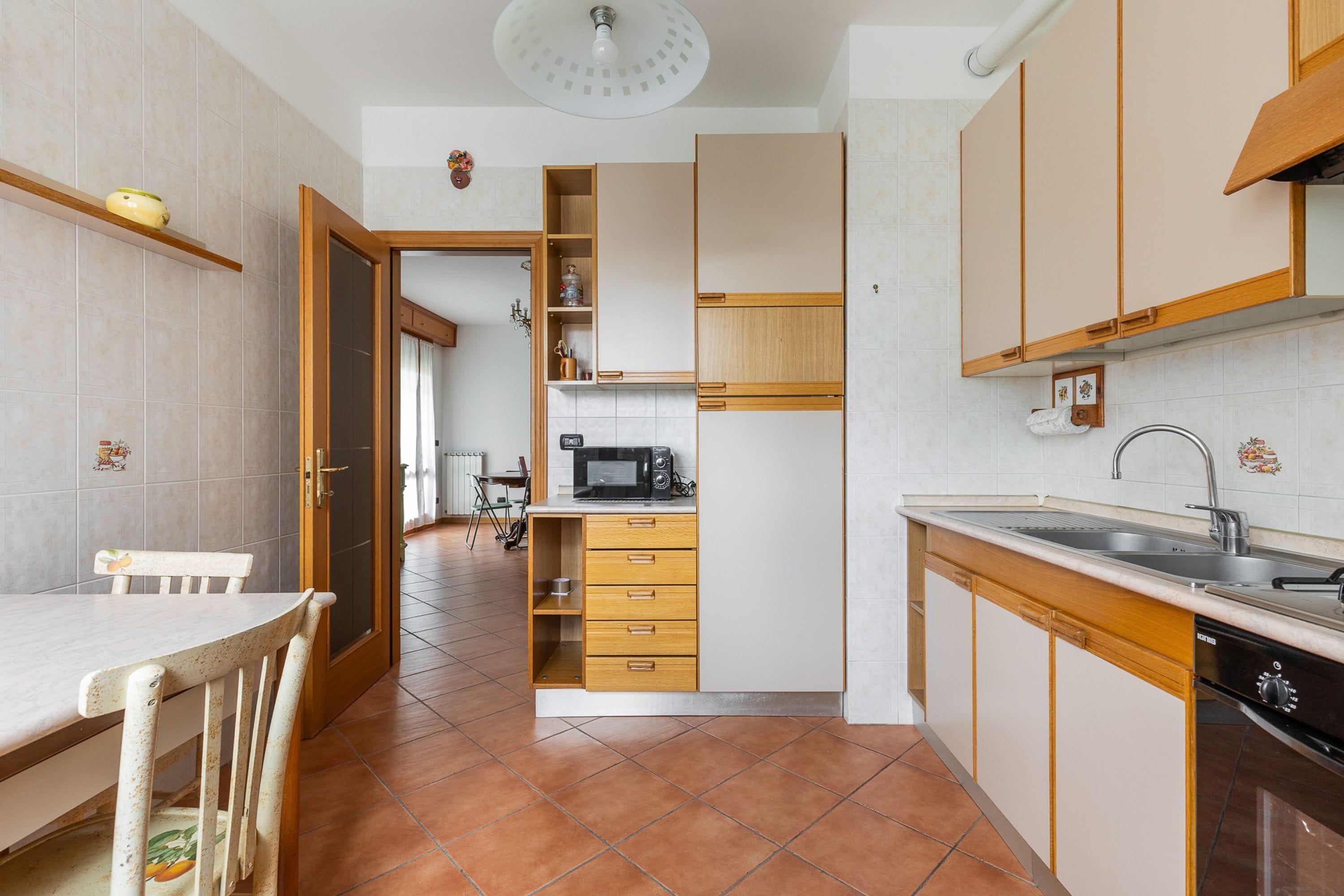 A kitchen with wooden cabinets, a microwave, and a sink.