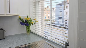 Eine Küche mit Fenster, Spüle und Schrank.