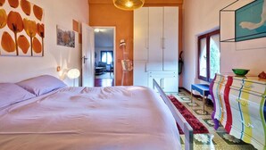 Una camera da letto con un letto, un armadio, una cassettiera e una finestra.