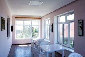Ein Zimmer mit großem Fenster, einem weißen Tisch und einem weißen Stuhl.