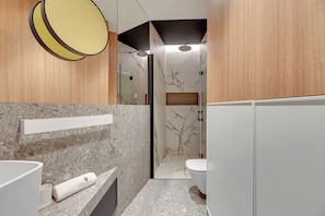 A modern bathroom with a marble countertop, a towel, a shower with a glass door, and wooden paneling. - Havana Premium Family Apartment Sopot (Sopot)