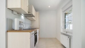 Eine moderne Küche mit Kaffeemaschine, Backofen und einem Fenster mit Blick.