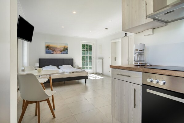 A modern bedroom with a bed, bedside table, and a TV.