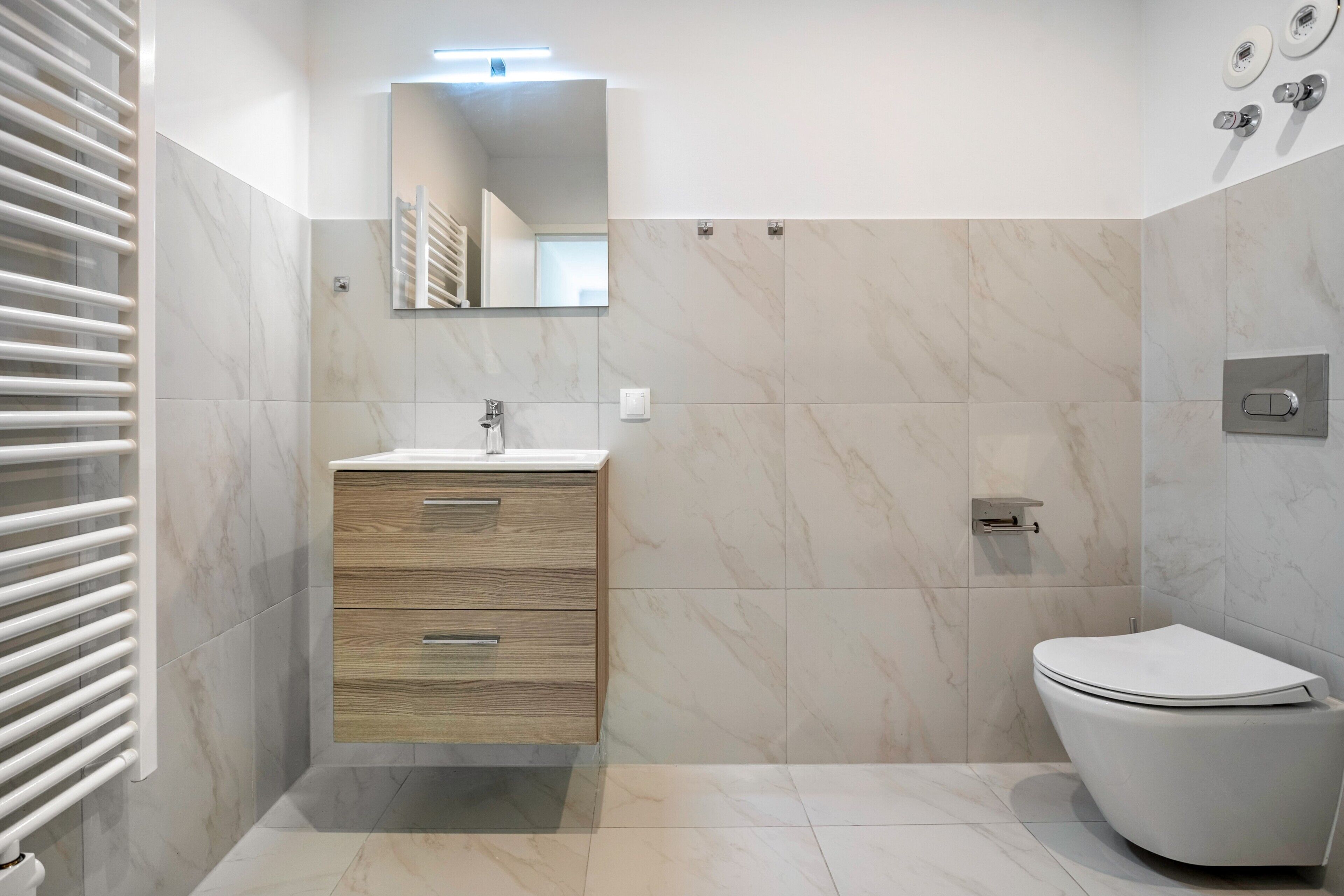 Une salle de bain moderne avec un meuble-lavabo en bois, des toilettes et une douche.