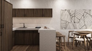 A modern kitchen with a central island, wooden cabinets, and a dining area with wooden chairs and a table. - Villa Oasis (Ubud)