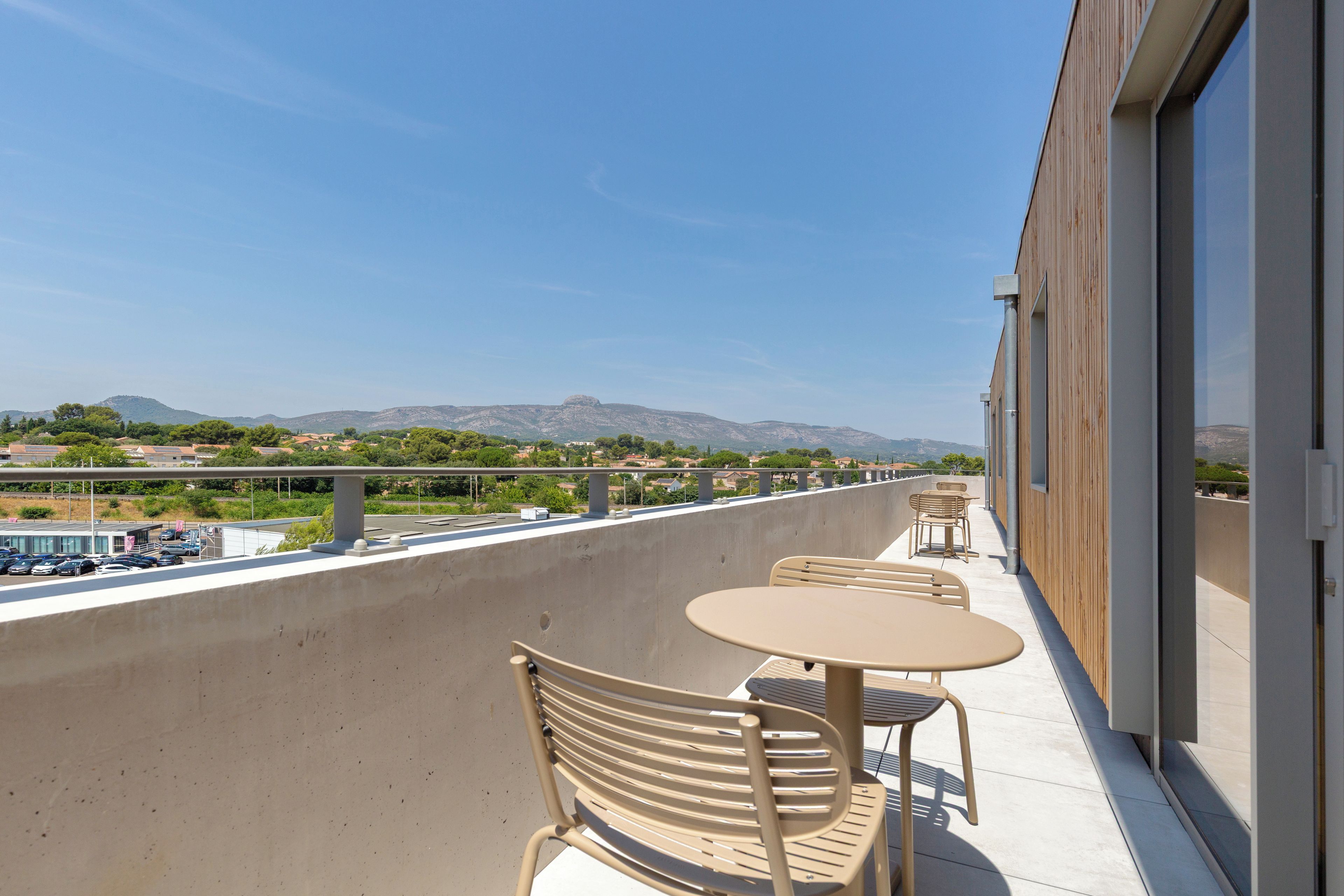 Un balcón con mobiliario exterior y vistas a un paisaje montañoso.