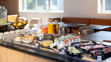 Ein reichhaltiges Frühstücksbuffet mit verschiedenen Speisen, darunter Käse, Wurstwaren und Getränke.