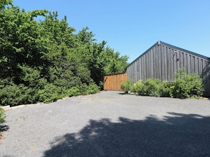 A gravel driveway leading to a wooden fence and a large grey building. - Brookview Goldfinch (Haverfordwest)