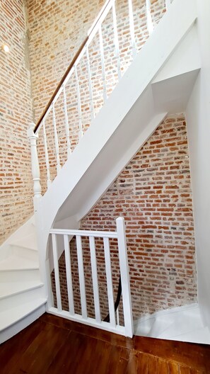Een witte trap met een bakstenen muur op de achtergrond.