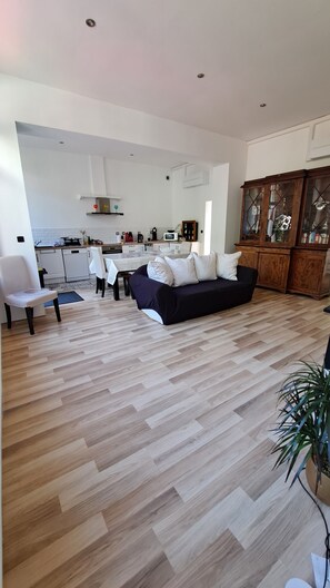 A modern living room with a sofa, dining table, and kitchen in the background. - Magnificent house in the heart of Douai (Douai)