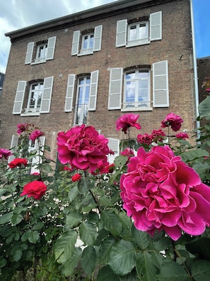A brick building with multiple windows and shutters.