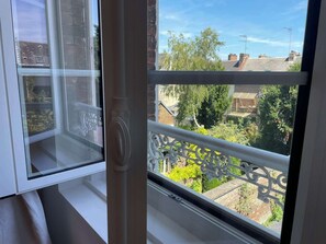 Ein Fenster mit Blick auf eine Wohngegend, darunter Häuser und Bäume.