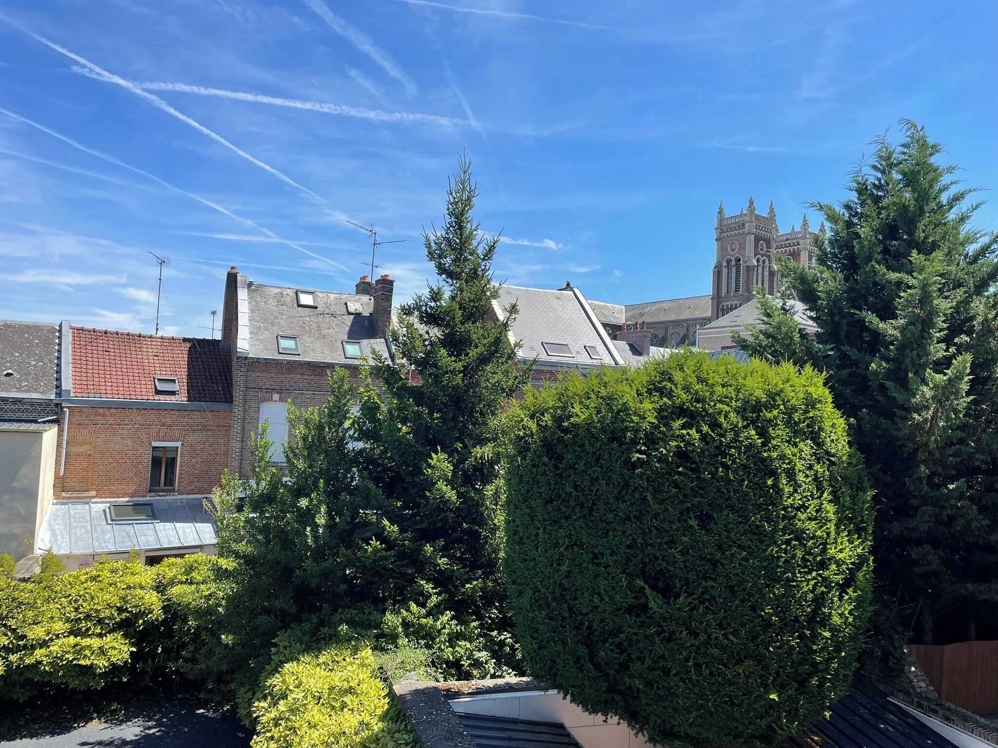 Een woonwijk met een kerk, een bakstenen gebouw en een verzorgde haag.