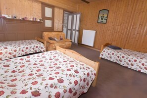 Huoneessa on kaksi puista sänkyä, puinen tuoli, patteri ja ovi, joka johtaa toiseen huoneeseen.