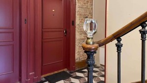 A red door, a wooden handrail, and a patterned floor. - Spacious Quiet Studio • Fully Equipped • Amiens Centre • 5-min Walk to Station • Parking on Site (Amiens)