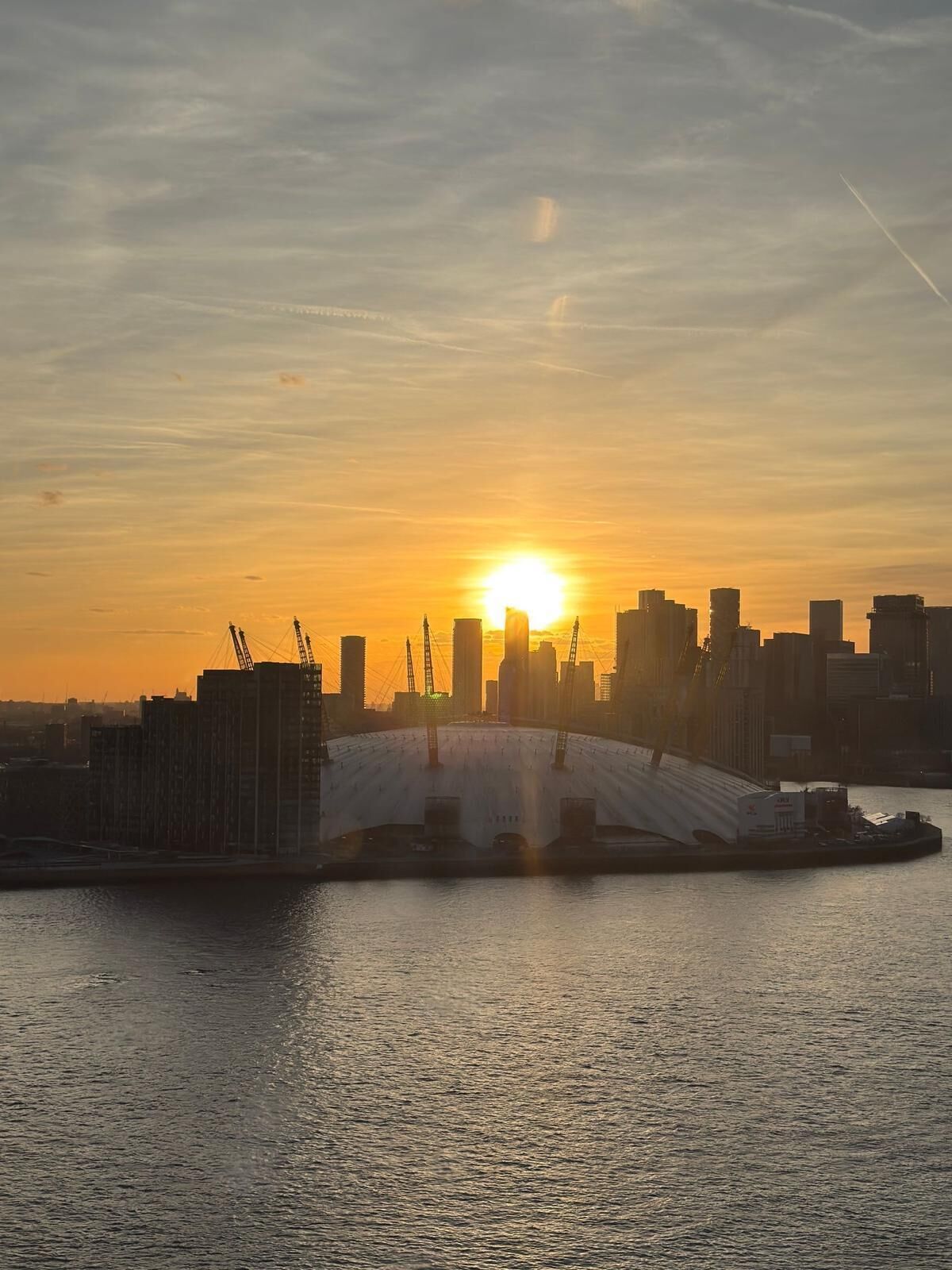 Un horizonte urbano al atardecer con un puente sobre el agua.