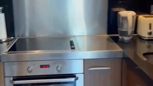Una cocina con electrodomésticos de acero inoxidable, armarios de madera y un tostador.