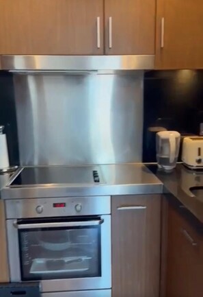 Eine Küche mit Edelstahlgeräten, Holzschränken und einem Toaster.