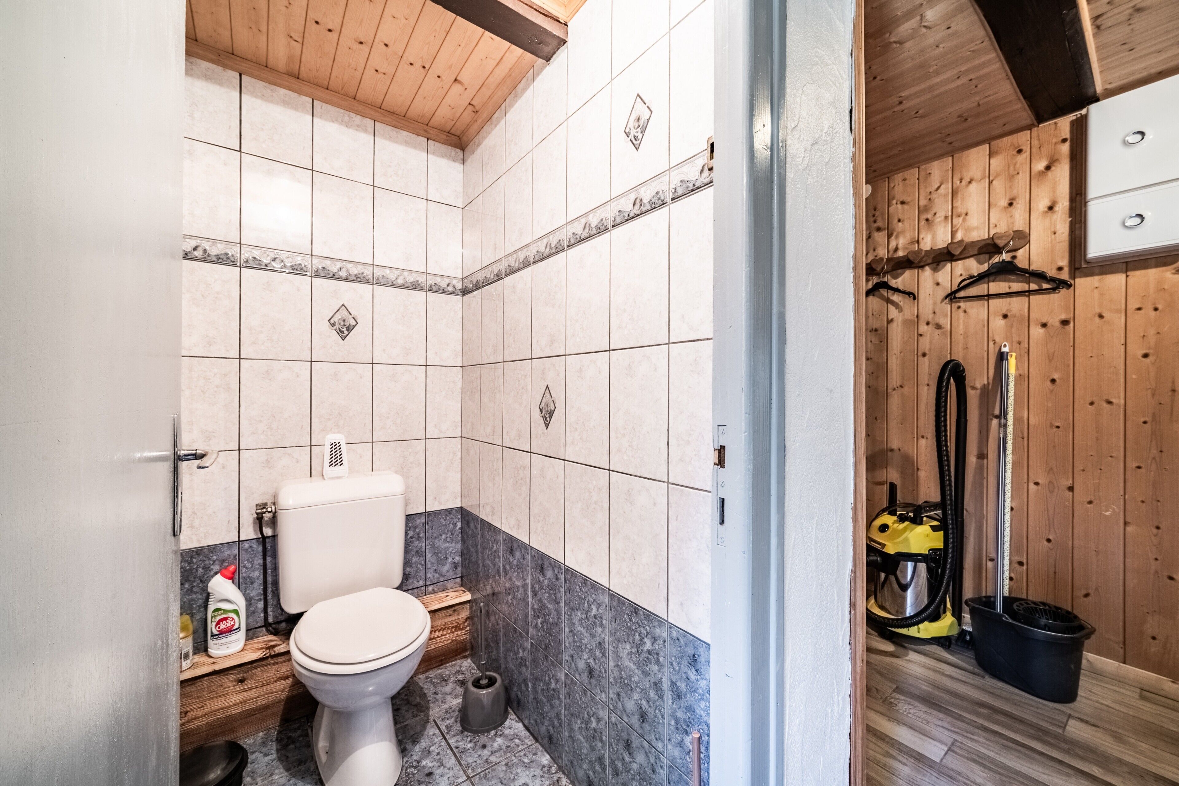 Et badeværelse med toilet, bidet og en støvsuger.