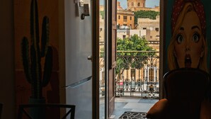 Una porta oberta que dona a un balcó amb vista a un edifici amb cúpules i una decoració de cactus a l'interior.