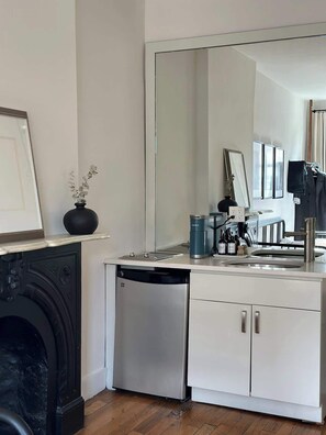 A compact kitchen with a dishwasher, a sink, and a large mirror. - Brooklyn artistic studio apartment! (Brooklyn)