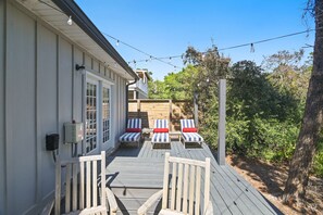 A wooden deck with lounge chairs and a railing, overlooking a garden with trees and shrubs. - 🌊Walk to Beach | 6 Bikes | 30A | Abbys Abode🌊 (Santa Rosa Beach)