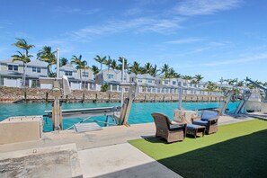 A waterfront property with a pool, lounge chairs, and a view of the ocean. - Duck Key Waterfront Paradise B Private Balcony (Duck Key)