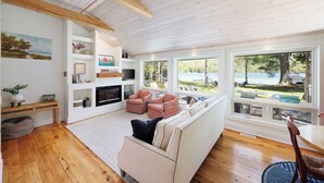 A spacious living room with a large window, a fireplace, and a cozy seating area.