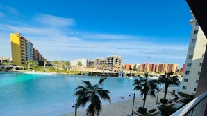 A hotel with a pool, palm trees, and a view of other buildings. - luxury hotel apartment porto golf marina (Marsa Matrouh Governorate)