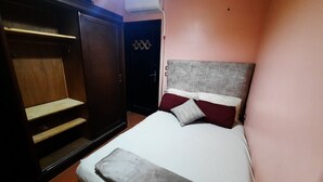 A bedroom with a bed, a wardrobe, and an air conditioning unit. - luxury hotel apartment porto golf marina (Marsa Matrouh Governorate)