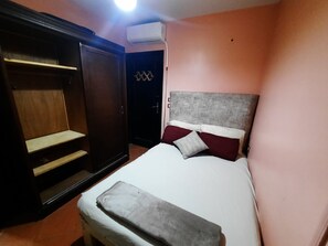 A bedroom with a bed, a wardrobe, and an air conditioning unit. - luxury hotel apartment porto golf marina (Marsa Matrouh Governorate)