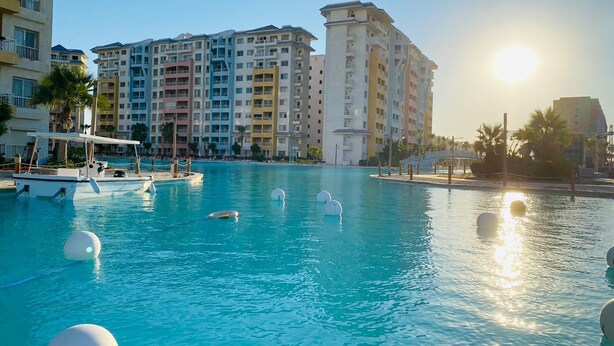 A swimming pool with boats, surrounded by multi-story buildings. - luxury hotel apartment porto golf marina (Marsa Matrouh Governorate)