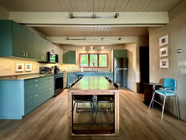 A modern kitchen with a central island, built-in appliances, and a large window.