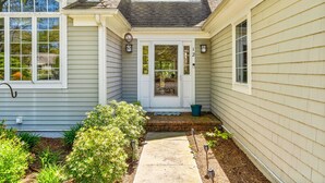 Une maison avec une porte d’entrée, un petit porche et un chemin menant à la porte.