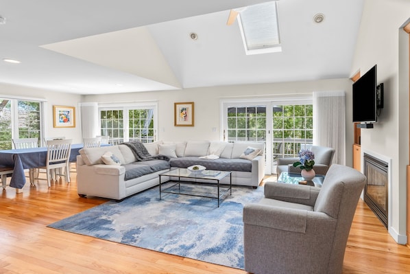 A modern living room with a sectional sofa, a coffee table, and a fireplace.