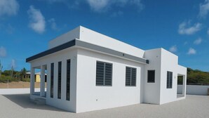A modern white building with large windows and a flat roof. - Casa Trankilo | Rest & beaches near Cas Abao (Bisento)