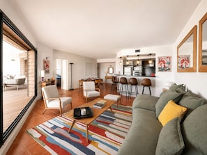 Un salon moderne avec un canapé, une table basse et un tapis coloré.