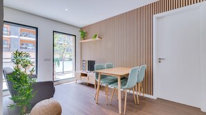 A modern interior with a dining area, a sofa, a coffee table, and a large window.