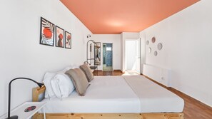 Ein Schlafzimmer mit einem Bett, einem Nachttisch, einem Spiegel und einer Tür zu einem Badezimmer.
