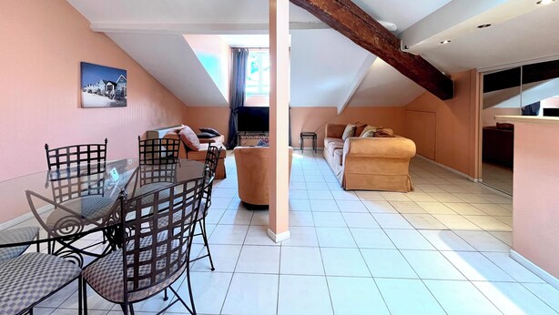 Un loft spacieux comprenant un coin repas, un espace salon et un téléviseur.