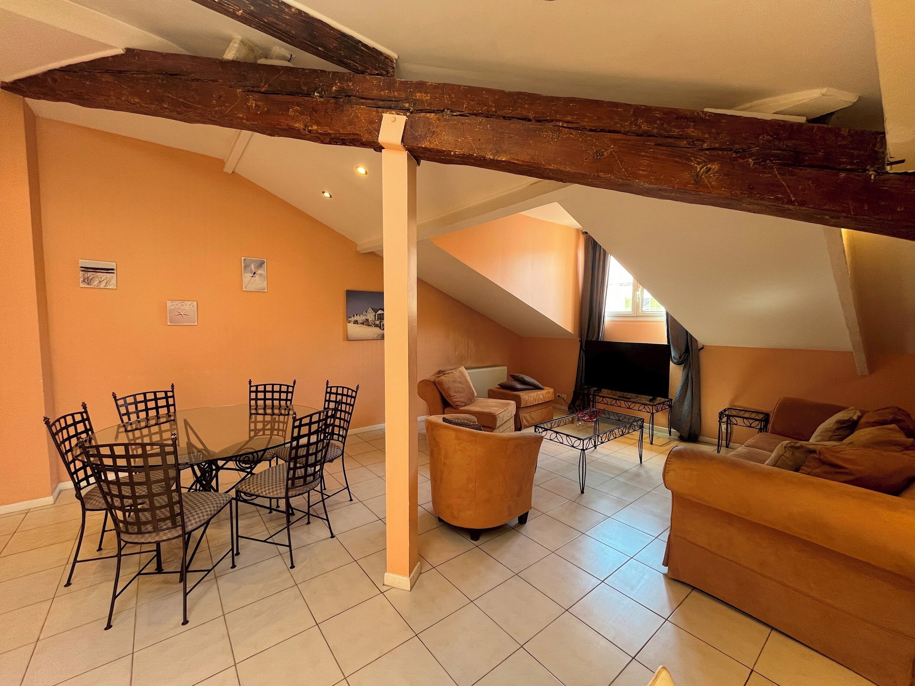 Ein gemütlicher Lofts-Wohnraum mit Essbereich, einer Couch und einem Fernseher.
