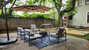 Eine Terrasse im Freien mit Schaukel, Tisch und Stühlen.