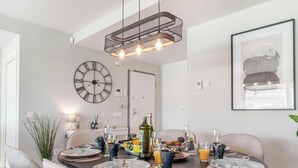 Zona pranzo con orologio, quadro incorniciato e tavolo apparecchiato per la colazione.