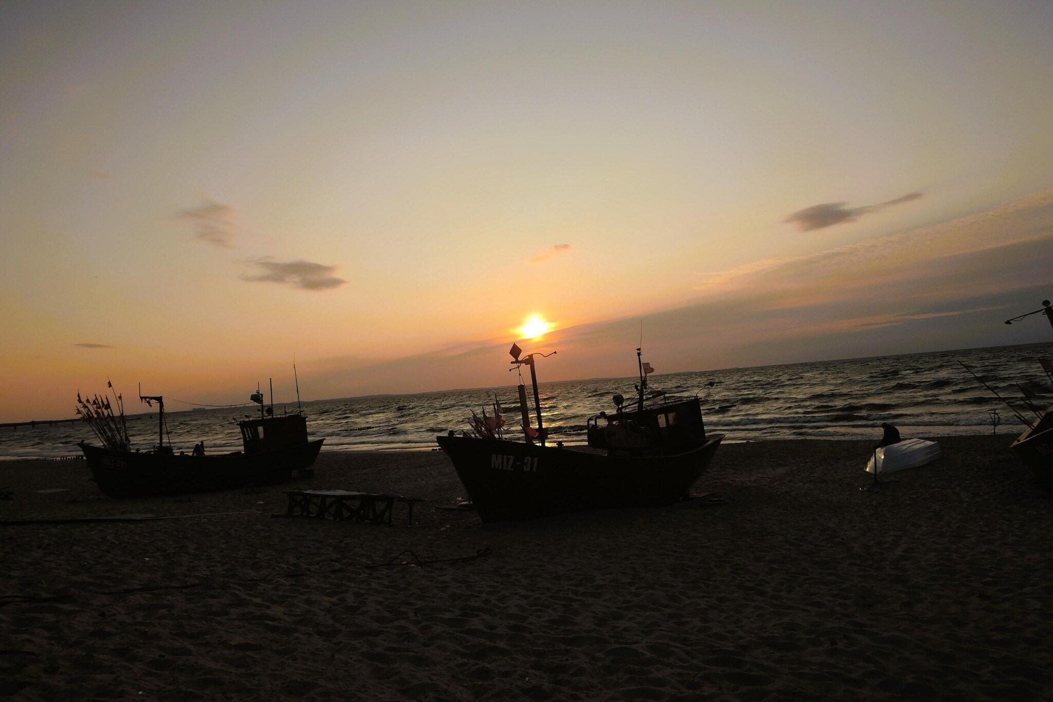 Boote an einem Strand bei Sonnenuntergang.