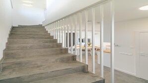 A staircase leading to a room with a dining area, white walls, and a door. - New holiday homes, Dziwnow (Dziwnów)