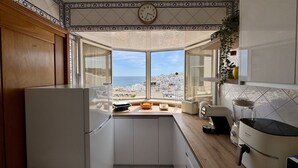Une cuisine avec vue sur la mer, une horloge et un design moderne.